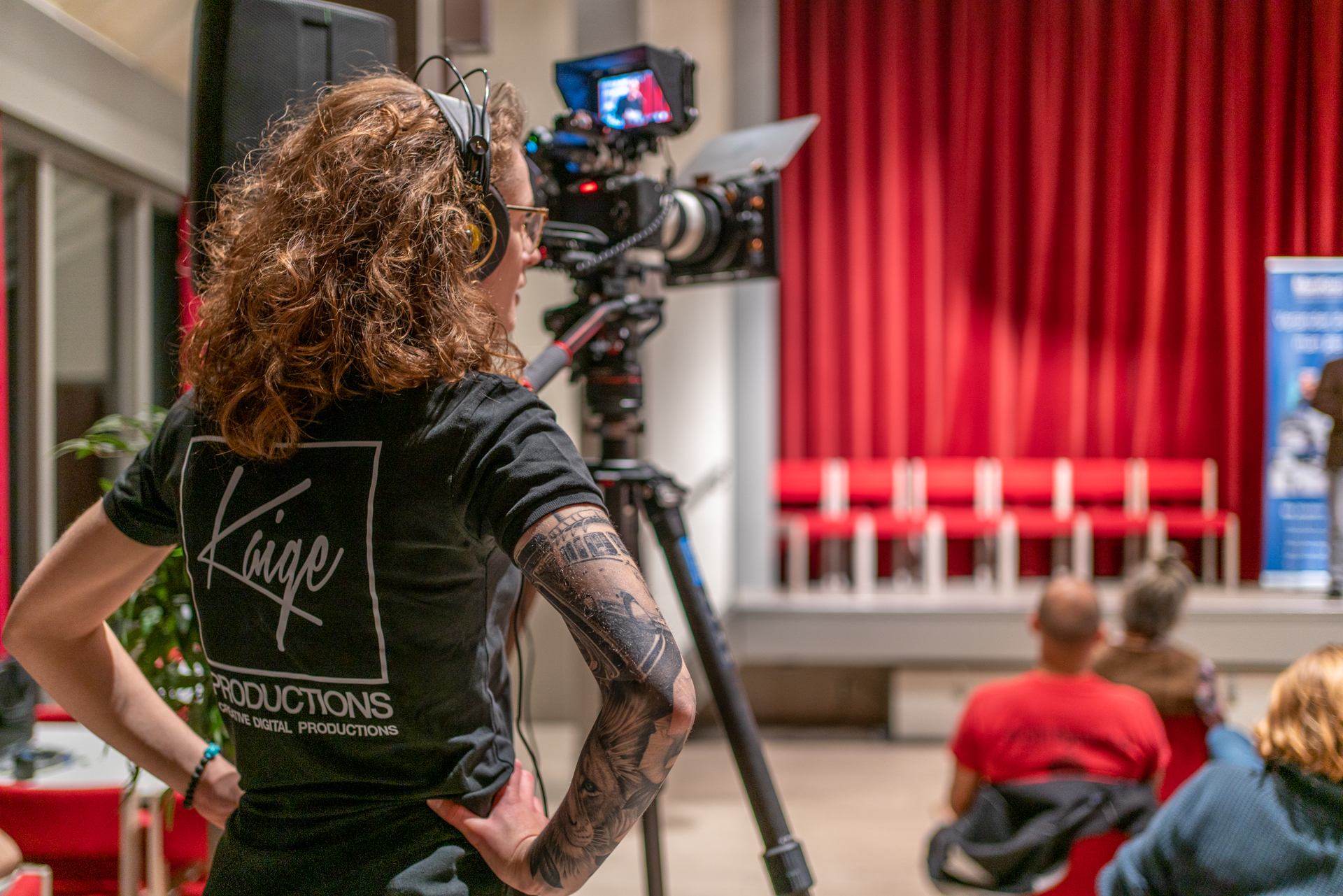 Cameraman van Kaige filmt een presentatie in een zaal
