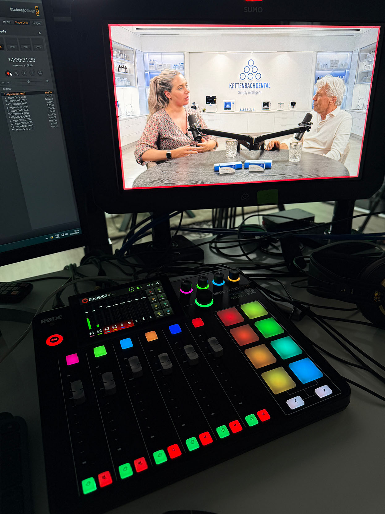 Audiomixer met vier kanalen tijdens een podcastopname in Breda, met op de monitor de twee sprekers in de virtuele set.